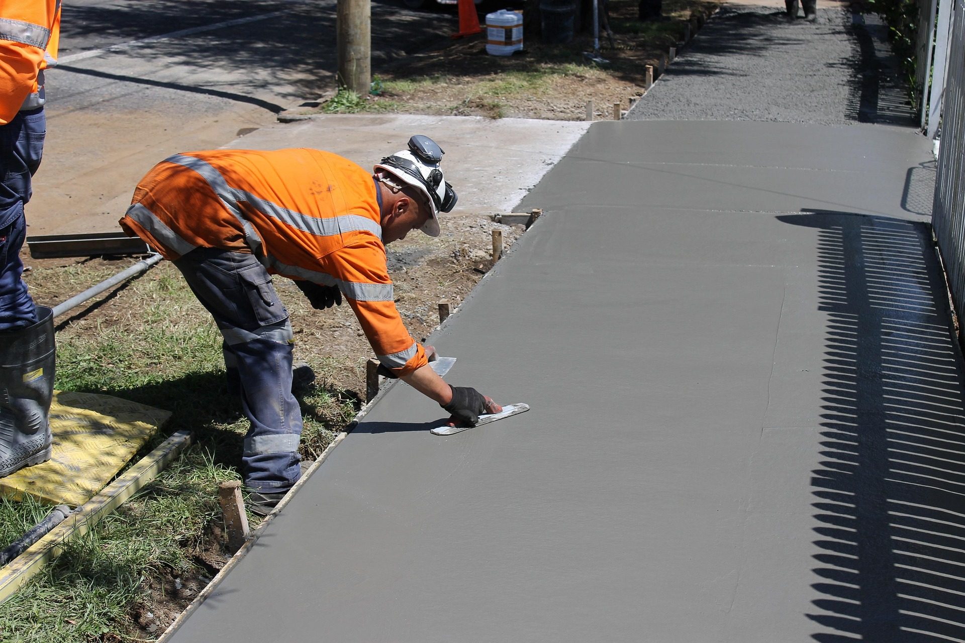 Worker finishing a freshly poured concrete sidewalk in Spartanburg, SC